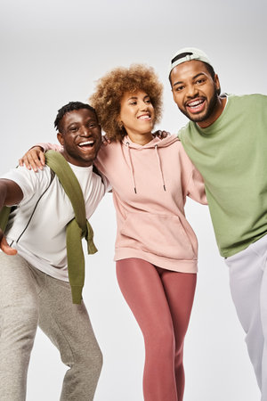 excited african american men and woman standing on grey background, Juneteenth celebration