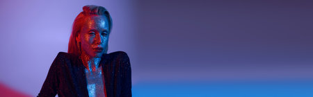 banner of alluring woman covered in glitter posing in shiny outfit under colored lights in studio