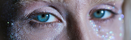 close up of attractive woman with highlighter on her face and green eyes looking at camera, banner