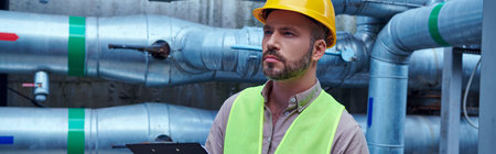 pensive technician in safety vest and yellow helmet outside of data center looking away, banner