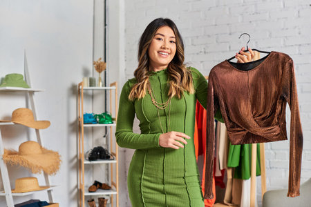 asian personal stylist with elegant bespoke blouse looking at camera in own atelier, small business
