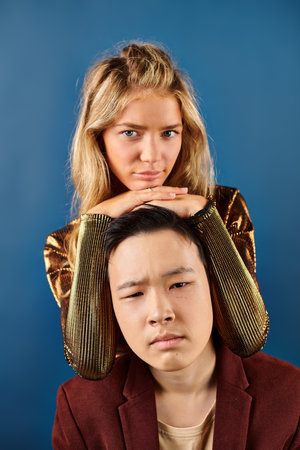 adorable multicultural stylish teenagers in vibrant clothes posing together and looking at cameraの写真素材