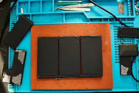 set of new batteries on work desk in electronics maintenance workshop, repair business conceptの写真素材