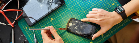 partial view of technician disconnecting broken touchscreen of smartphone in repair workshop, bannerの写真素材