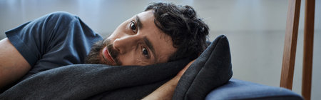 depressed man in casual outfit lying on sofa during breakdown, mental health awareness, banner