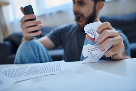 depressed suffering man screaming at his smartphone during depressive episode, mental health