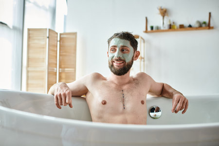 joyous handsome man with beard and face mask chilling in his bathtub, mental health awarenessの写真素材