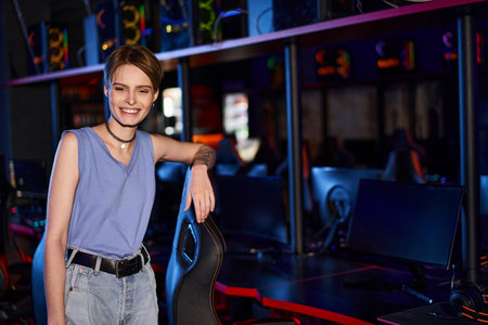 A fashion-forward woman gazes confidently in her stylish attire while leaning on chair