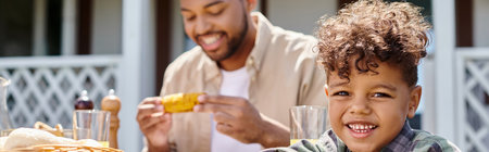 cheerful african american kid having family bbq with father on backyard of house, bannerの写真素材