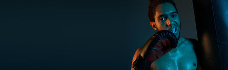 appealing african american man with boxing gloves next to pear and looking at camera, bannerの写真素材