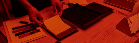 cropped banner of photographer skillfully prepares a film negative for development in darkroomの写真素材