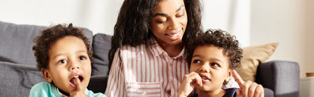 cheerful attractive african american woman posing with her little adorable sons, Mothers day, bannerの写真素材