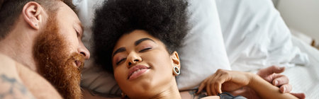 tattooed man with beard lying next to curly african american girlfriend in bedroom, bannerの写真素材