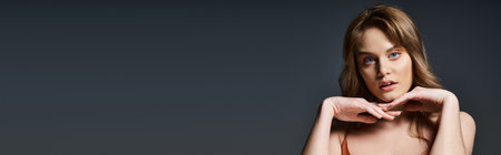 Beauty portrait of an attractive sensual young woman touching her face, posing in studio, bannerの写真素材