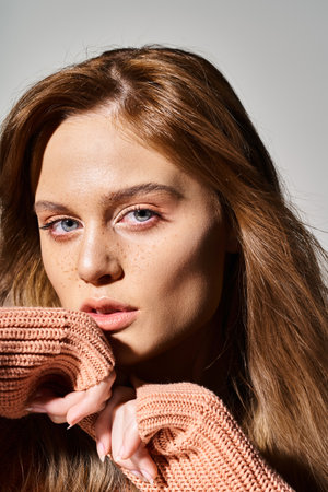 Closeup beauty portrait of sexy woman with peach makeup and freckles on grey background