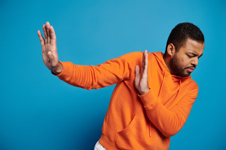 worried african american man in vibrant outfit with closed eyes refusing and hiding behind hands