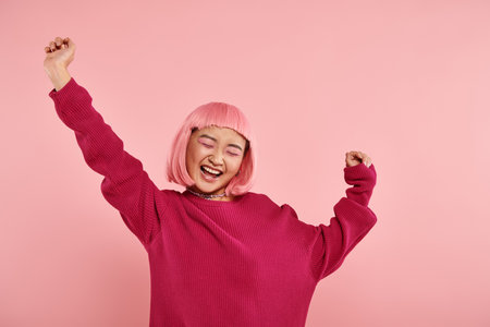 attractive asian woman in her 20s with pink hair very happy on vibrant backgroundの写真素材