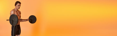 young shirtless sporty man in black pants exercising with barbell on vibrant orange backdrop, bannerの写真素材