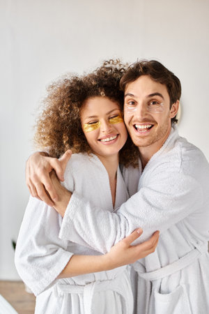 Portrait of couple with eye patches  hugging in bathroom and smiling, looking at cameraの写真素材