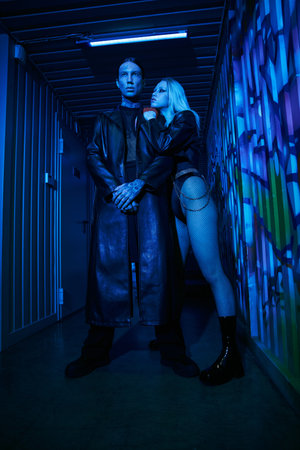 A man and a woman are standing in a hallway, possibly at a rave party or nightclubの写真素材