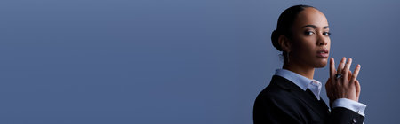 A young African American businesswoman in a stylish suit holding her hands together, bannerの写真素材