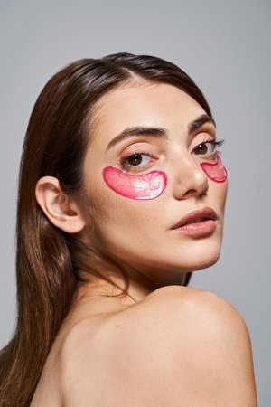 close up of young woman with brunette hair showcases vibrant pink patches on her faceの写真素材