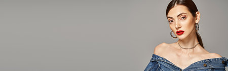 A young Caucasian woman with brunette hair stuns in a denim dress paired with bold red lipstick, bannerの写真素材