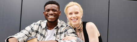 A happy multicultural couple, a man and a woman, sit harmoniously next to each other on an urban...