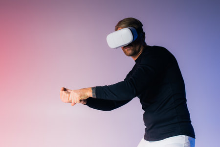 A man wearing a virtual reality headset in a studio setting, fully engrossed in the digital world.の写真素材
