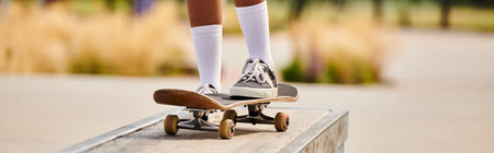 Young African American woman skilfully skateboarding on top of a metal rail at an outdoor skate...