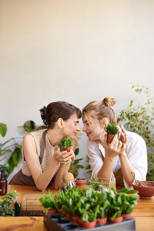 Two women sitting closely, sharing a moment of love and connection in an art studio.の写真素材