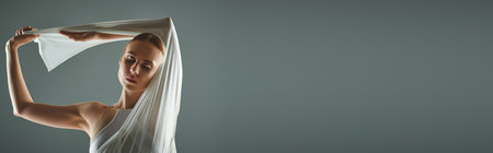 Ballerina in white dress gracefully holds cloth over head.