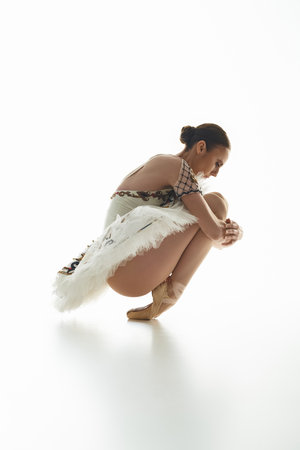 A young, beautiful ballerina in a costume gracefully kneels.の写真素材