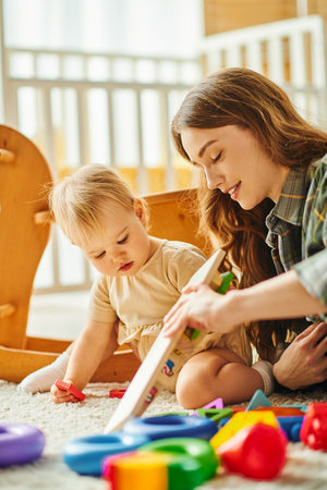A young mother and her toddler daughter enjoy quality time together, playing with toys on the floor in a cozy home setting.の写真素材
