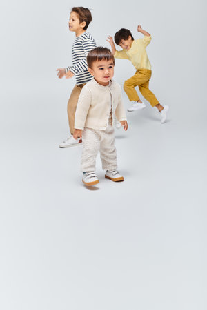 Group of young children, standing closely together in a studio against a grey background.の写真素材