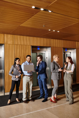 Diverse group of business people standing in front of elevators.