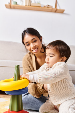 A young Asian mother joyfully playing with her little son on the floor in their cozy living room.の写真素材