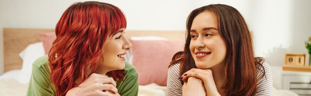 happy young lesbian couple in casual attire having cozy moment and looking at each other, banner