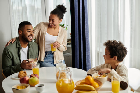 African american family at a table sharing a meal and enjoying each others company.