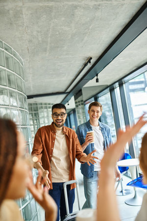 group of businesspeople and friends standing and chatting in a stylish hotel lounge during a...