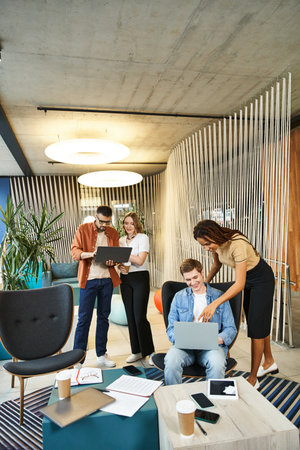 A diverse group of colleagues discuss ideas in a modern living room setting, embodying the essence...