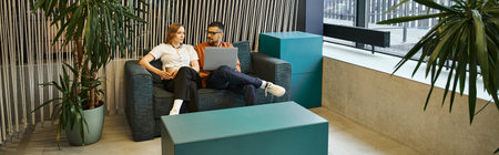 Two coworkers relax and chat on a couch in a modern workspace, reflecting a startup teams dynamic...