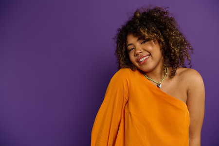 Stunning African American woman striking a pose in a vibrant orange dress.