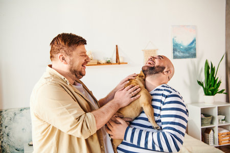 A man lovingly holds a French Bulldog in a cozy living room setting.の写真素材