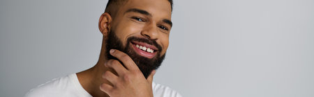 Close-up of a handsome young man tending to his beard.