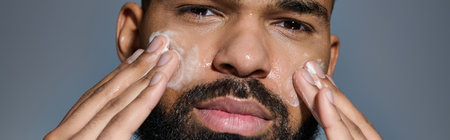 Handsome man with beard holds hands to face in a moment of reflection.の写真素材