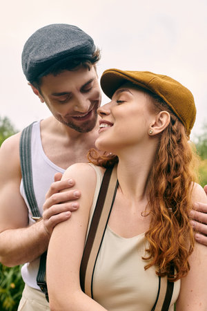 A man and a woman standing closely, embraced in a romantic moment in a verdant park setting.の写真素材
