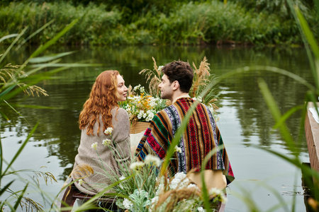 A man and a woman relax on a boat as it gently glides on the water, surrounded by the tranquility of nature.の写真素材