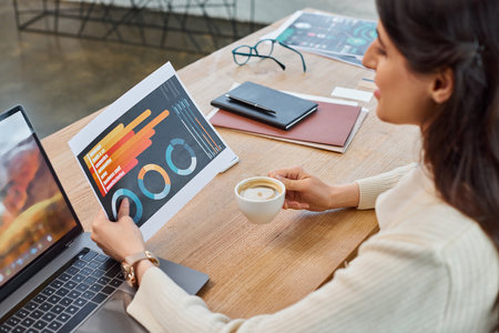 A businesswoman seated at a table with a laptop in a modern office setting, embodying the franchise...