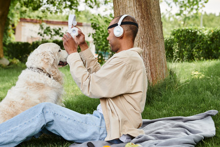 A disabled African American man with myasthenia gravis syndrome sits on the grass next to a loyal...